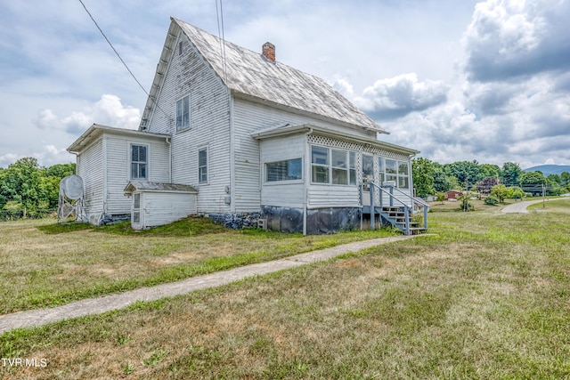 view of side of home with a yard