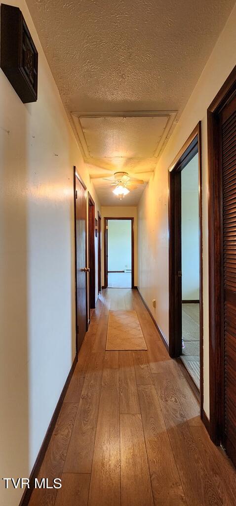 hallway featuring a textured ceiling and light wood-type flooring