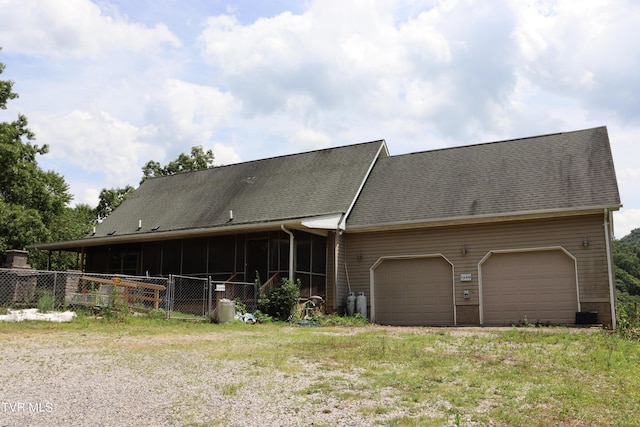 view of front facade featuring a garage and a sunroom