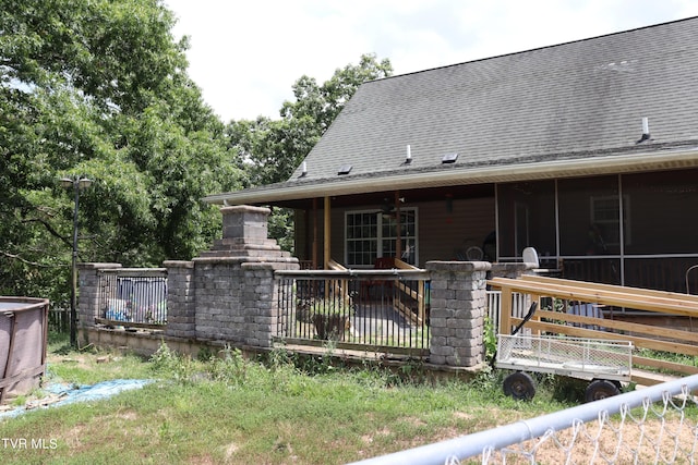 rear view of property featuring a sunroom