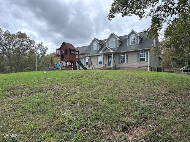 view of front of property with a playground, central AC unit, and a front lawn