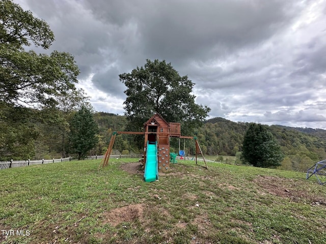 view of jungle gym featuring a mountain view and a lawn