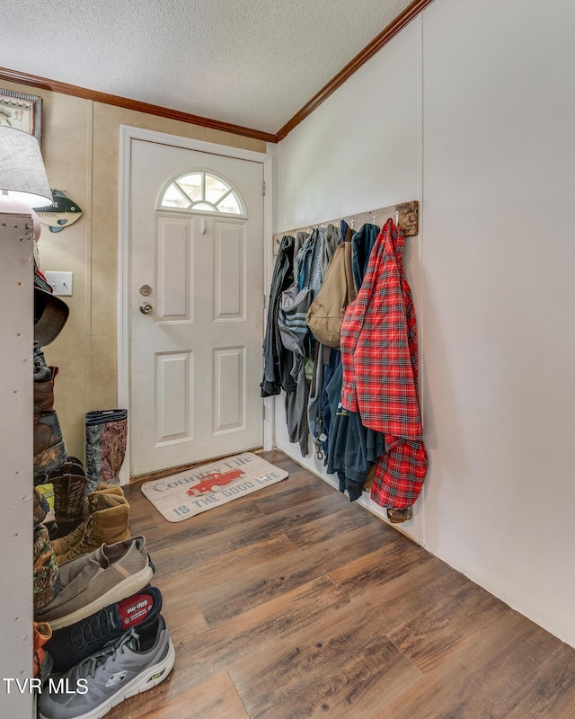 entryway with crown molding, hardwood / wood-style floors, and a textured ceiling