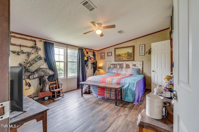 bedroom with lofted ceiling, crown molding, a textured ceiling, ceiling fan, and hardwood / wood-style floors