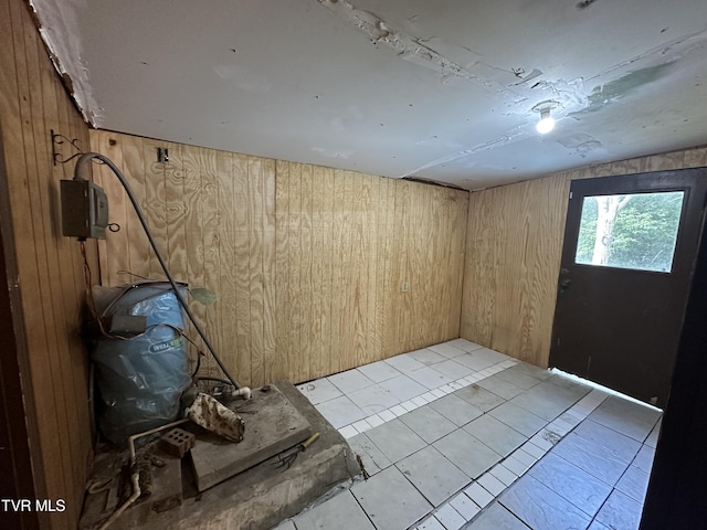 unfurnished room featuring light tile patterned flooring and wooden walls