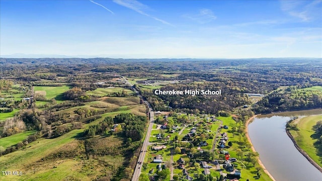 birds eye view of property featuring a water view and a wooded view