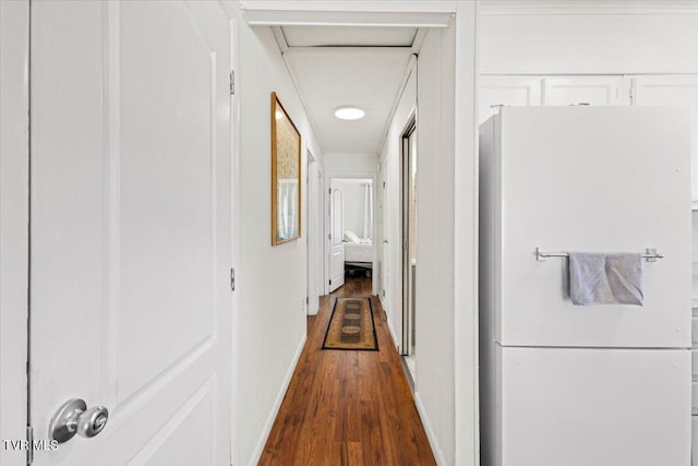 hallway with dark wood-style flooring and baseboards