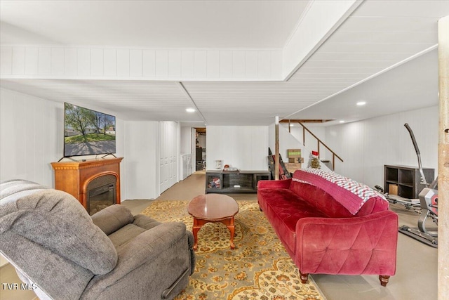 living area featuring concrete floors, stairs, and a fireplace