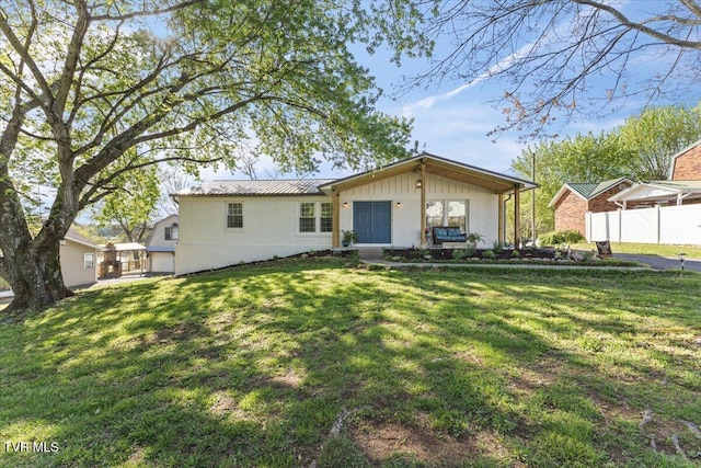 back of house featuring fence and a lawn