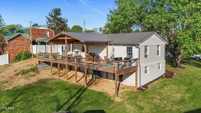 back of house with metal roof, fence, a deck, and a lawn