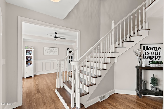 stairs featuring ceiling fan and hardwood / wood-style flooring