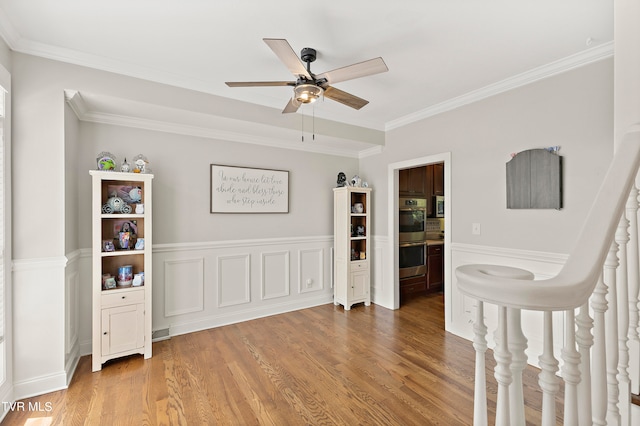 bedroom featuring ornamental molding, wood-type flooring, and ceiling fan