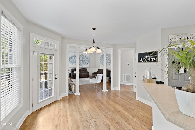 interior space with a chandelier and light hardwood / wood-style floors