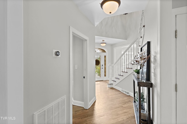 foyer with lofted ceiling and light hardwood / wood-style flooring