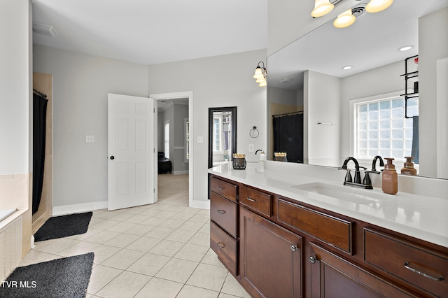 bathroom with a tub, tile patterned flooring, and vanity