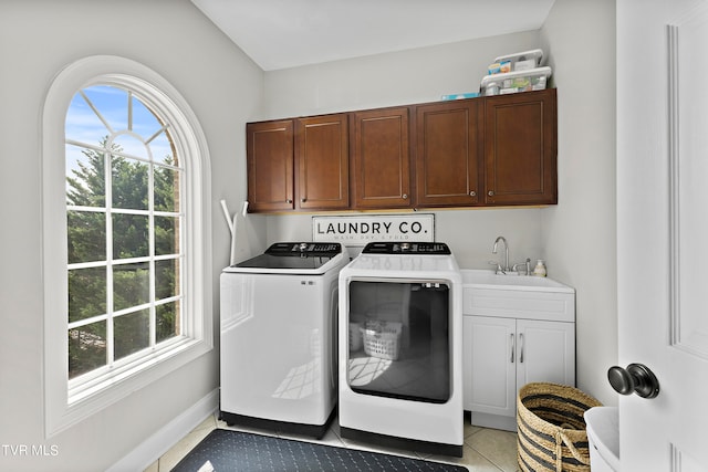 clothes washing area with washer and dryer, cabinets, sink, and light tile patterned floors