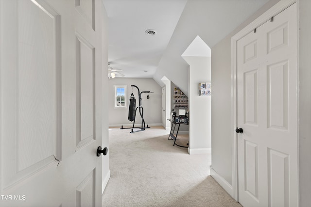 interior space featuring ceiling fan, light carpet, and vaulted ceiling