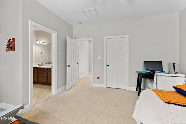 interior space featuring connected bathroom, light carpet, and ceiling fan