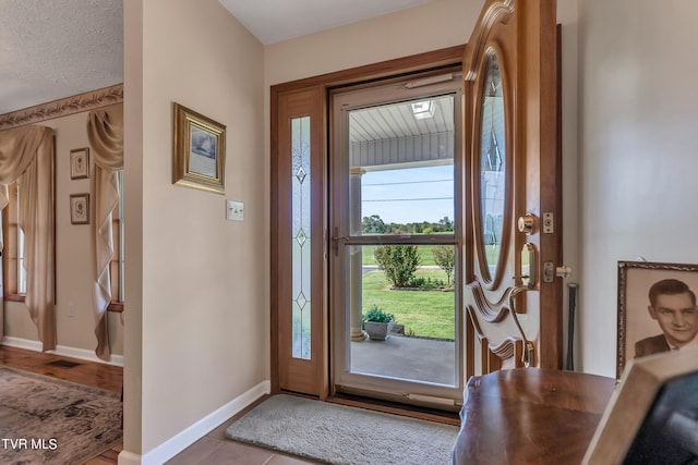 entrance foyer with light wood-type flooring and a textured ceiling