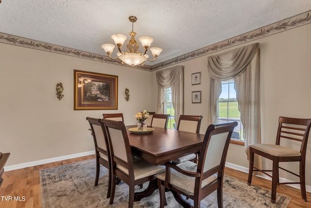 dining area featuring a textured ceiling, a chandelier, and hardwood / wood-style floors