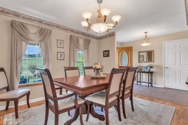 dining area with a textured ceiling, an inviting chandelier, and hardwood / wood-style floors