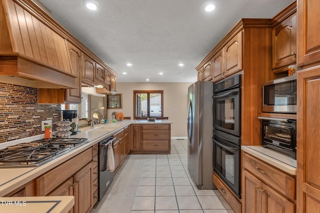 kitchen featuring custom range hood, stainless steel appliances, sink, kitchen peninsula, and light tile patterned flooring