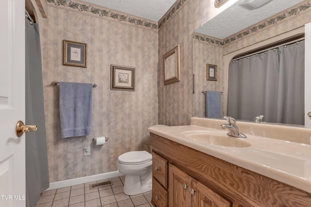 bathroom with tile patterned flooring, toilet, a textured ceiling, and vanity