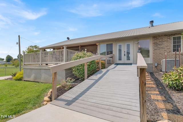 exterior space featuring french doors, a lawn, a wooden deck, and central air condition unit