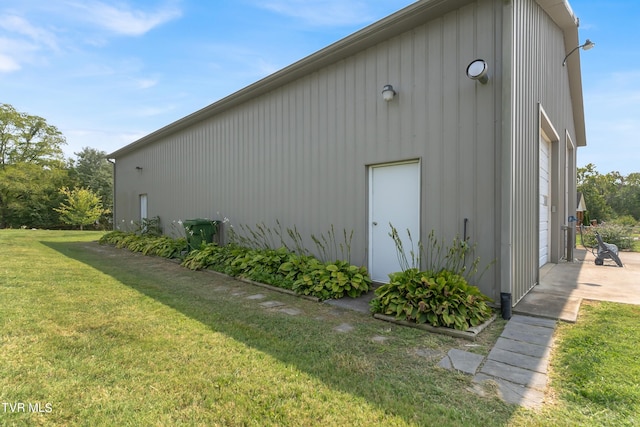 view of side of property featuring a yard and a garage