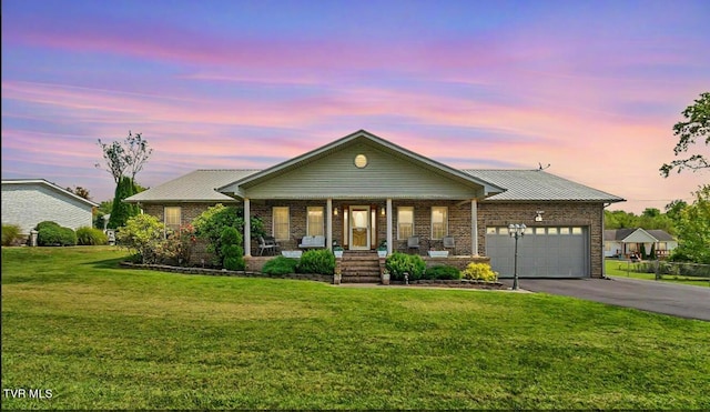 view of front facade with a lawn, a garage, and covered porch