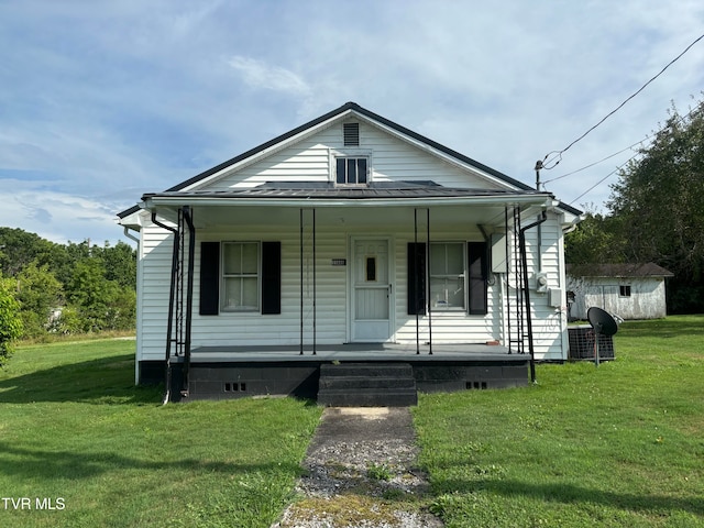 bungalow-style house with a porch, a shed, and a front yard