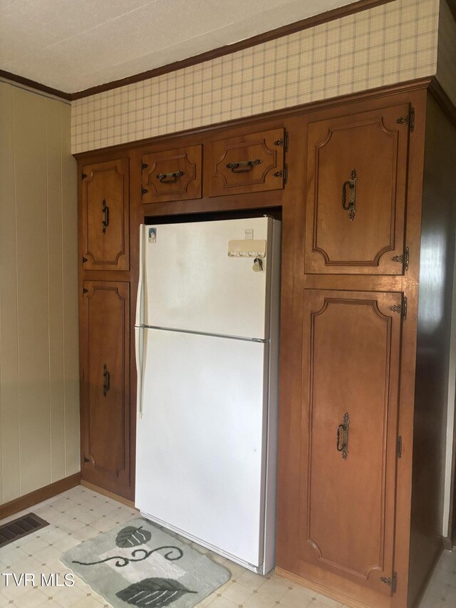 kitchen with ornamental molding and white fridge