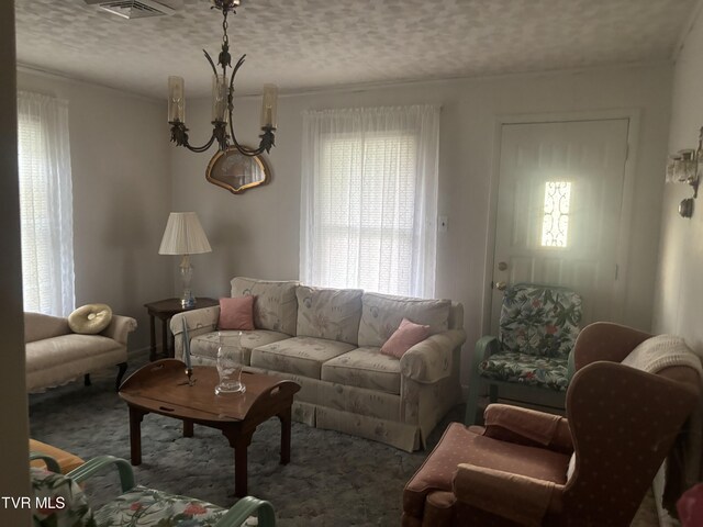 living room with a textured ceiling and a notable chandelier