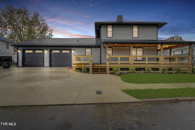 view of front facade featuring a lawn, a wooden deck, and a garage