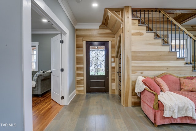 foyer entrance featuring plenty of natural light, wood-type flooring, and ornamental molding