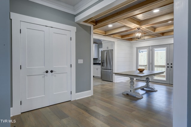 interior space featuring ornamental molding, coffered ceiling, beam ceiling, light hardwood / wood-style flooring, and a chandelier