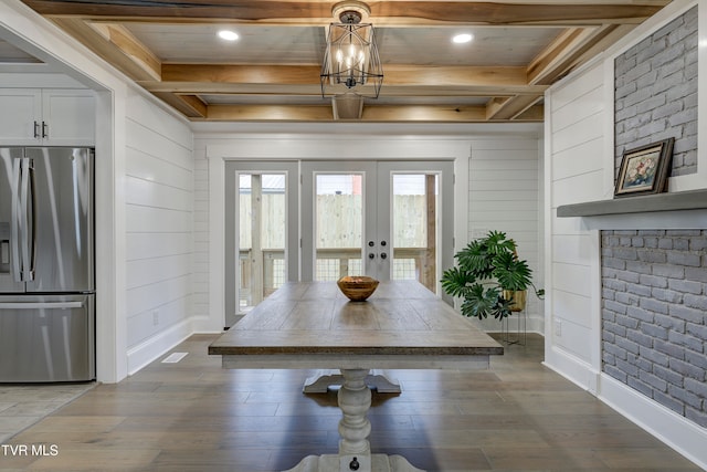 dining area featuring a notable chandelier, dark hardwood / wood-style floors, beam ceiling, and french doors