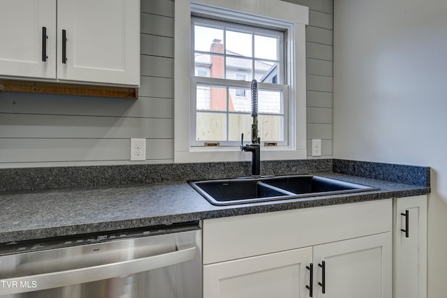 kitchen with dishwasher, white cabinetry, and sink