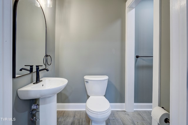 bathroom featuring hardwood / wood-style flooring and toilet