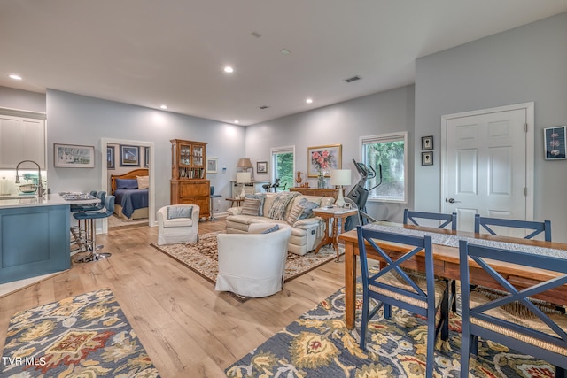 living room with light hardwood / wood-style flooring and sink