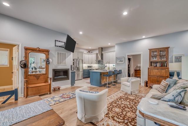 living room with sink and light wood-type flooring