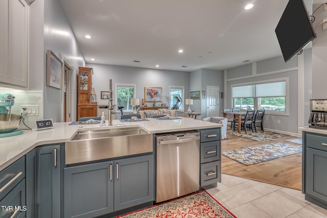 kitchen featuring gray cabinets, light wood-type flooring, sink, dishwasher, and backsplash