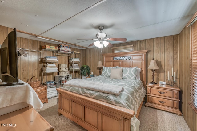 bedroom featuring wood walls, light carpet, and ceiling fan