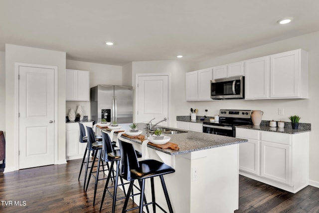 kitchen featuring an island with sink, white cabinetry, stainless steel appliances, and sink