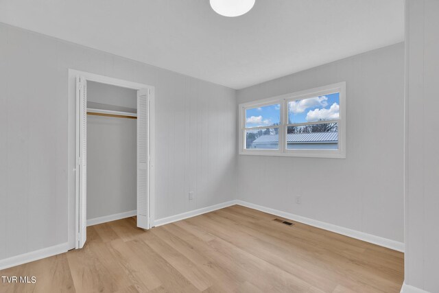 unfurnished bedroom featuring light hardwood / wood-style flooring and a closet