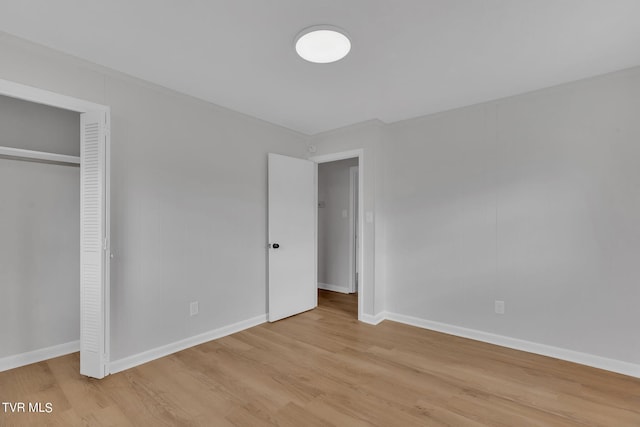 unfurnished bedroom featuring a closet and light wood-type flooring