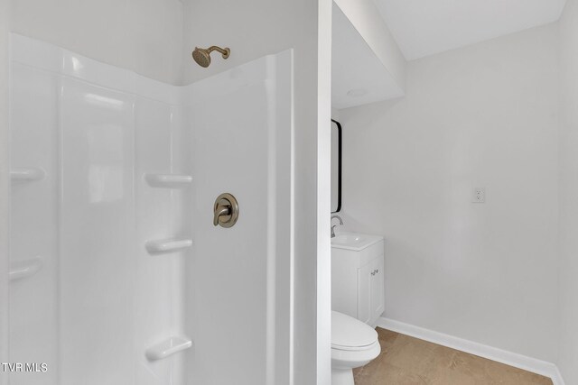 bathroom featuring tile patterned floors, toilet, vanity, and a shower