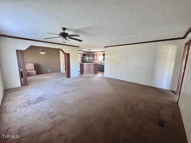 unfurnished living room with carpet, a textured ceiling, ceiling fan, and crown molding