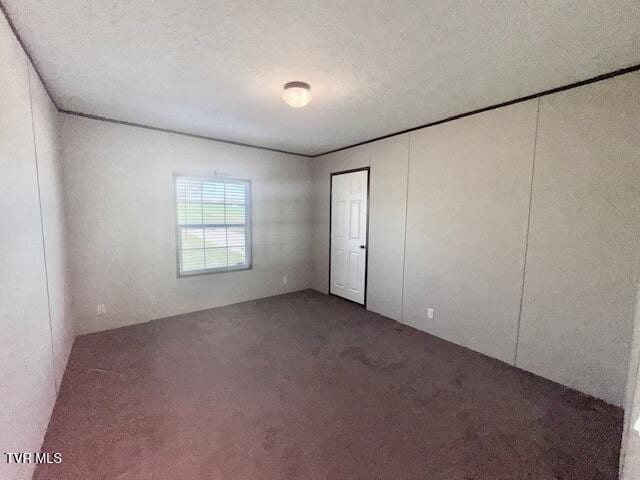 carpeted spare room featuring a textured ceiling