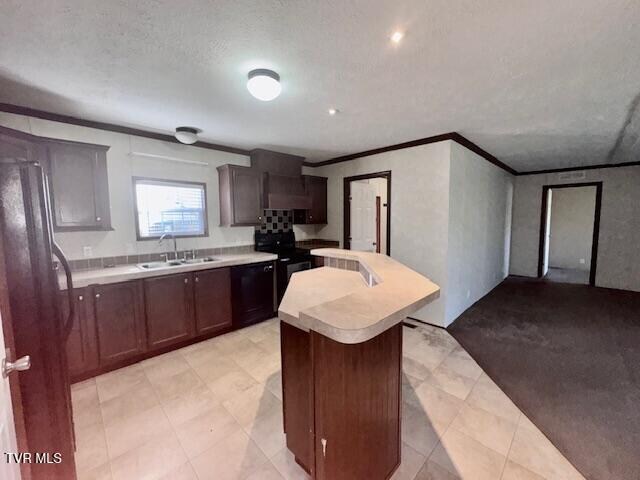 kitchen with sink, black electric range oven, crown molding, a textured ceiling, and a kitchen island